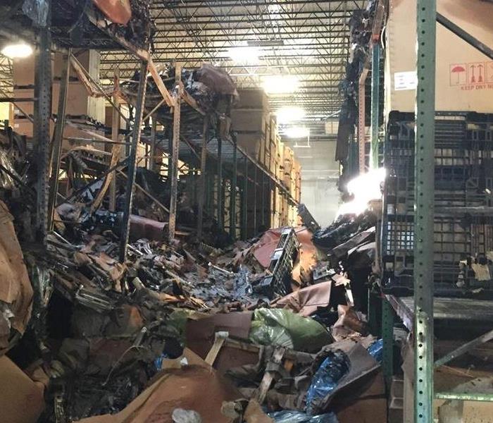 Warehouse destroyed and boxes are a mess on the ground from a large water loss. 