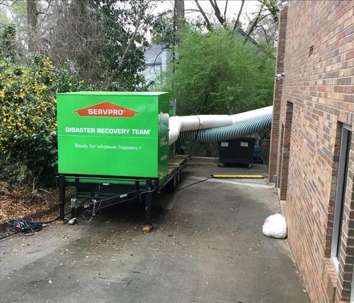 SERVPRO Green Trailer Mount Dehumidifier at a water damage restoration project with large drying tubes connected